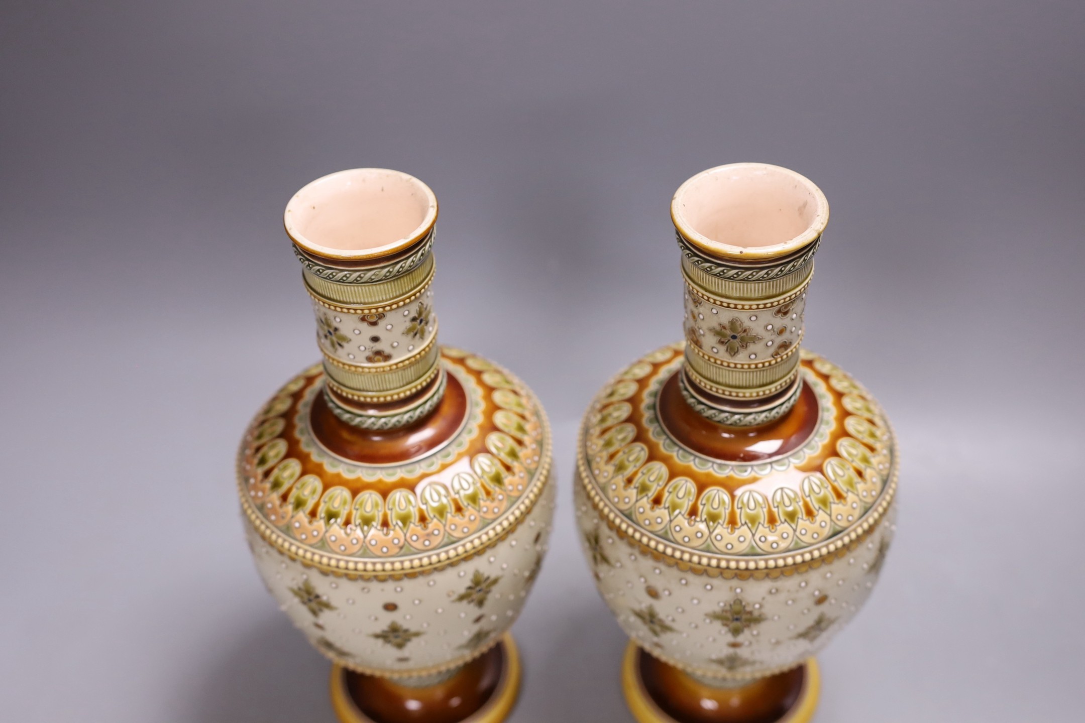 A pair of late 19th century Mettlach vases, 26 cms high.